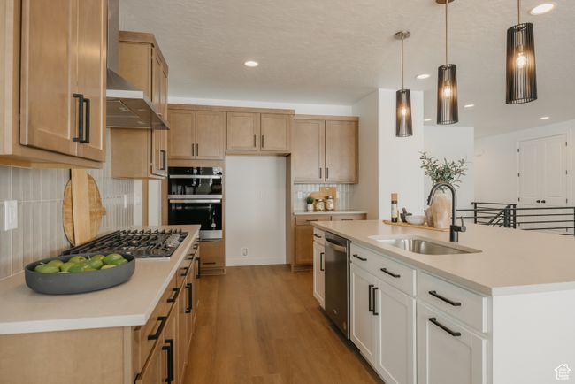Kitchen with a sink, appliances with stainless steel finishes, tasteful backsplash, light countertops, and light wood-style floors | Image 21