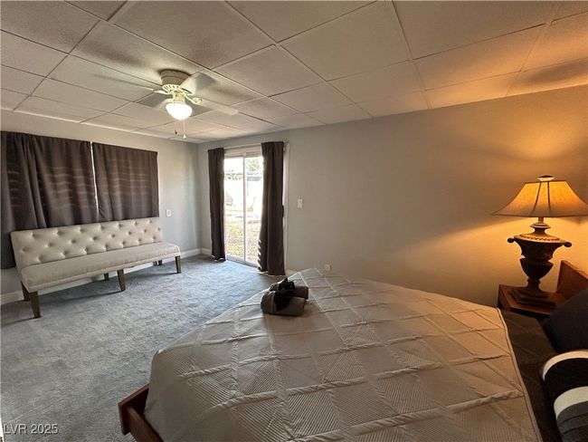Bedroom featuring access to exterior, carpet flooring, a ceiling fan, and a drop ceiling | Image 16