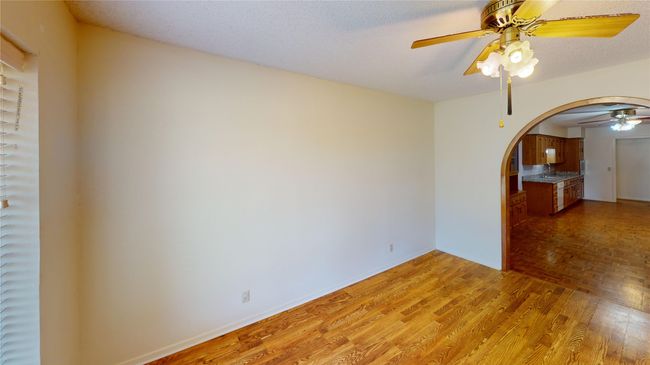 Unfurnished room with arched walkways, a ceiling fan, light wood-type flooring, a sink, and baseboards | Image 5