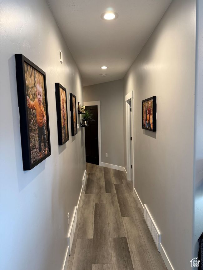 Hall featuring dark wood-type flooring, baseboards, visible vents, and recessed lighting | Image 18