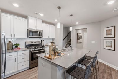 (Photo of decorated model, actual home's finishes may vary slightly) Soaked in natural sunlight, the homes eat-in dining room has ample space for a dining table located in the heart of the home. | Image 2