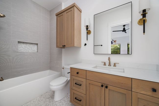 Bathroom featuring tile patterned flooring, shower / bathing tub combination, vanity, and toilet | Image 26
