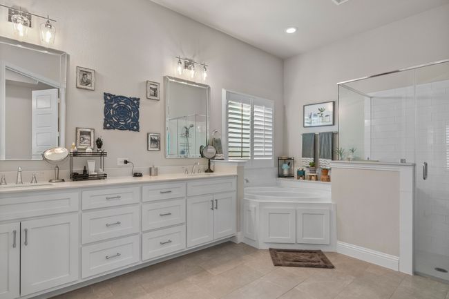 Bathroom with double vanity, a garden tub, a stall shower, and a sink | Image 16