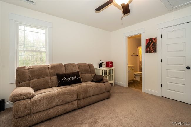 Living room featuring carpet flooring, baseboards, attic access, and ceiling fan | Image 27