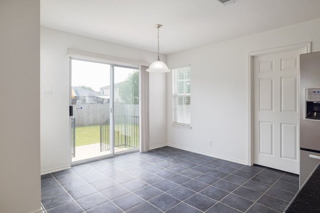 Unfurnished dining area with baseboards and dark tile patterned flooring | Image 15