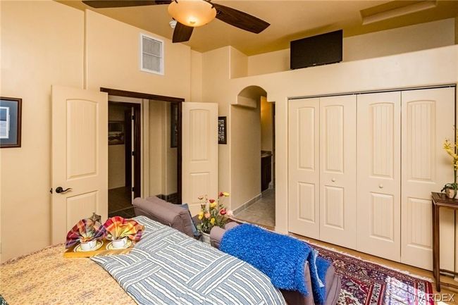 Bedroom with a closet, a ceiling fan, a towering ceiling, and arched walkways | Image 65