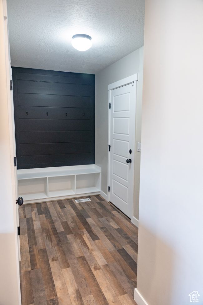 Mudroom with a textured ceiling and wood finished floors | Image 10