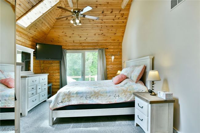 Carpeted bedroom featuring log walls, high vaulted ceiling, and wooden ceiling | Image 25
