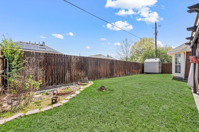 View of yard featuring a storage unit, a fenced backyard, and an outdoor structure | Image 35