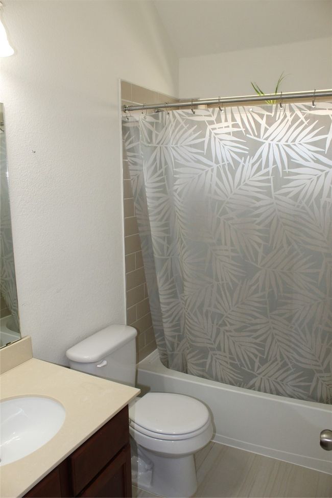 Bathroom with shower / bath combo with shower curtain, vanity, and toilet | Image 8