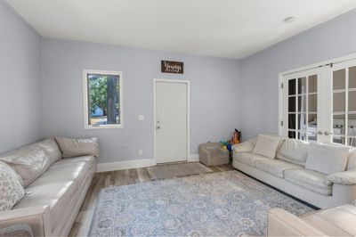 Bright and open, the lower-level living room features durable LVP flooring that extends throughout much of the unit. | Image 2