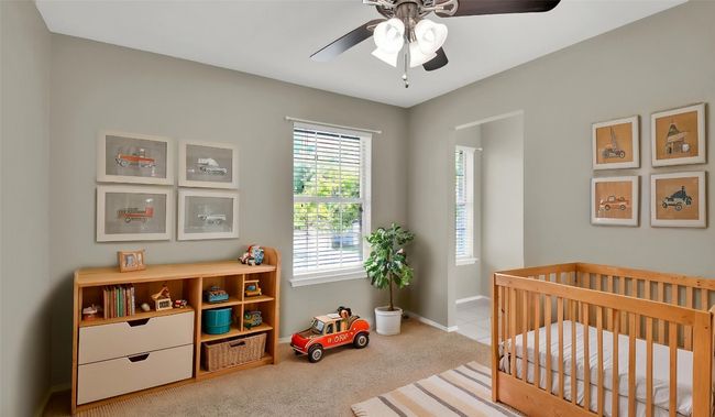 Bedroom with a nursery area, carpet flooring, baseboards, and a ceiling fan (virtually staged) | Image 17