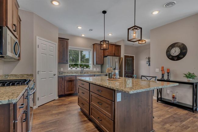 Gas range, SS appliances, large island with custom drawers and plenty of room for in kitchen seating | Image 9