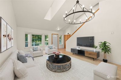 Well-appointed formal living room with gleaming hardwood floors, vauled ceilings and a skylight is virtually staged. | Image 3