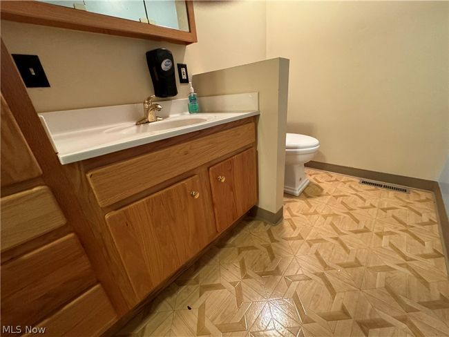 Bathroom featuring parquet floors, vanity, and toilet | Image 16