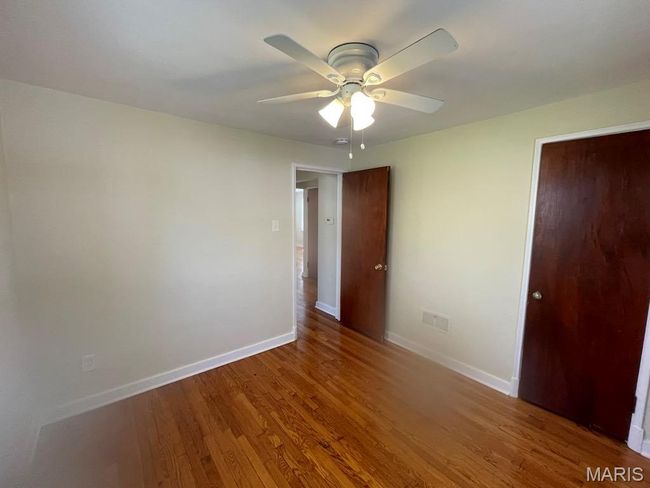 Unfurnished bedroom featuring baseboards, wood finished floors, and ceiling fan | Image 14