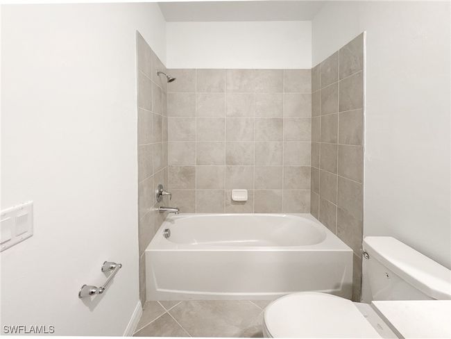 Bathroom featuring toilet, shower combination, and tile patterned floors | Image 19