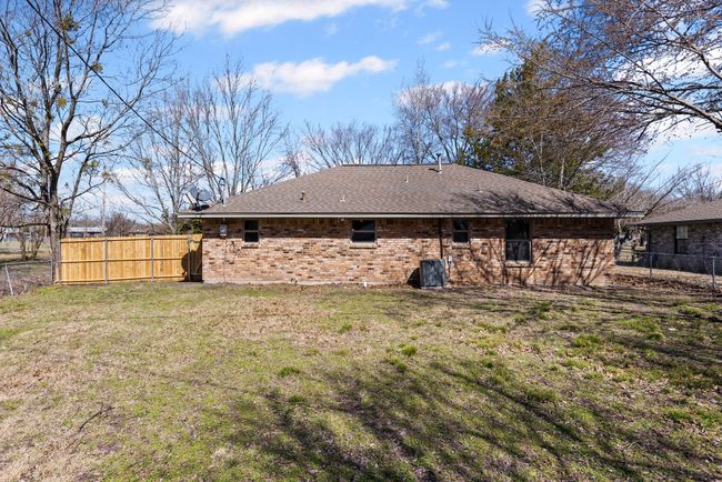 Rear view of property with brick siding, roof with shingles, fence, and a yard | Image 9