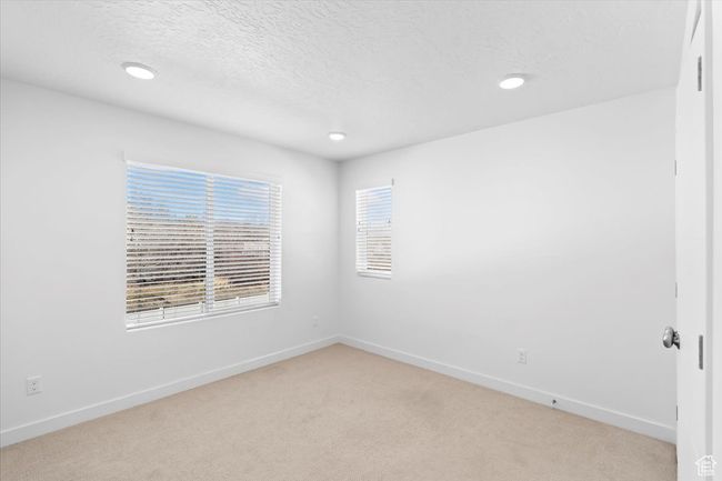 Spare room with recessed lighting, a textured ceiling, baseboards, and light carpet | Image 23