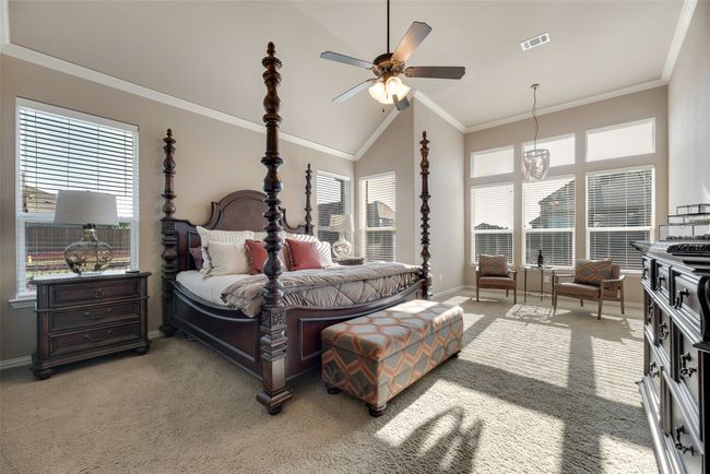 Bedroom with light colored carpet, crown molding, high vaulted ceiling, and a ceiling fan | Image 12
