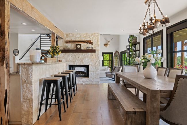 Dining room featuring healthy amount of natural light, light wood-style floors, a high end fireplace, stairs, and recessed lighting | Image 21
