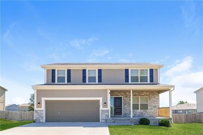 View of front of house with a front yard, a porch, and a garage | Image 1