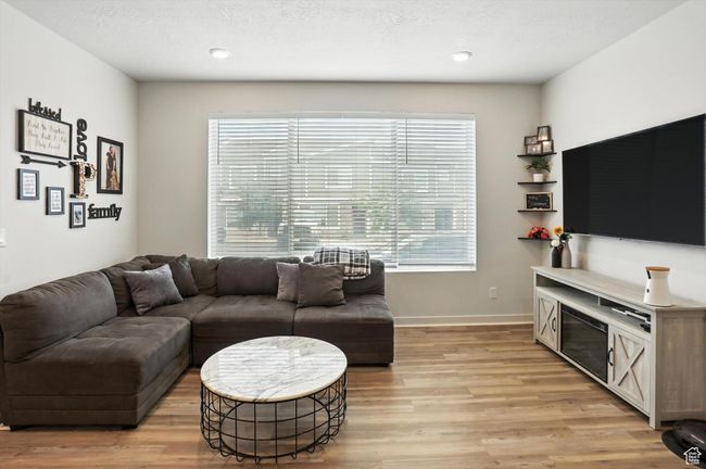 Living area with new light wood-style LVP floors and recessed lighting | Image 26