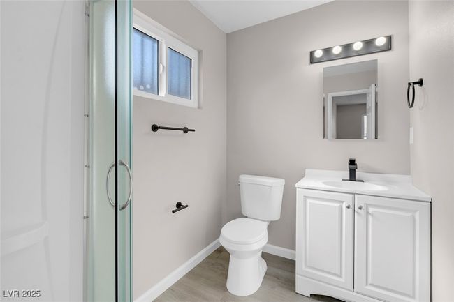 Bathroom with baseboards, wood finished floors, vanity, and toilet | Image 23