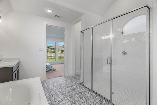 Ensuite bathroom featuring a shower stall, a bath, vanity, vaulted ceiling, and baseboards | Image 33