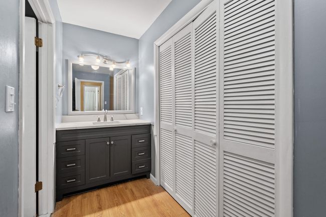 Bathroom with wood finished floors, vanity, and a closet | Image 8