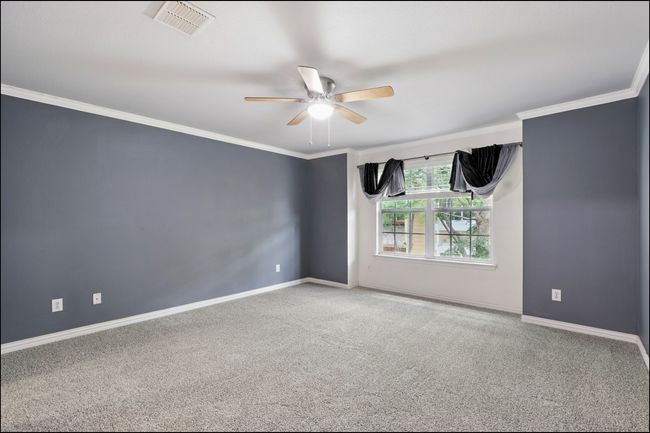 Unfurnished room with ceiling fan, visible vents, carpet floors, baseboards, and ornamental molding | Image 16