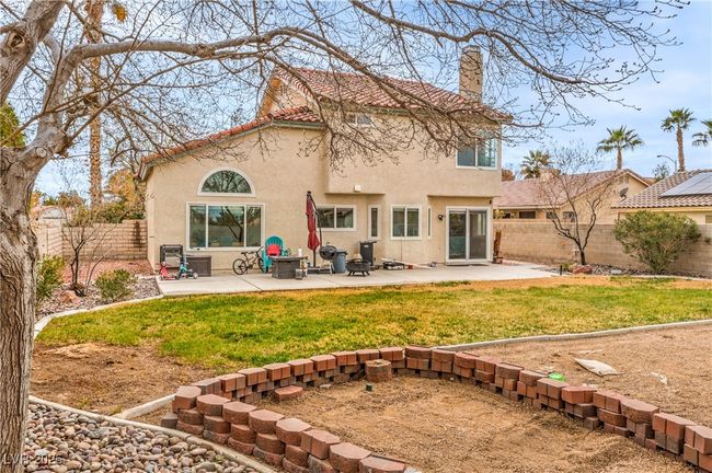 Rear view of house with a patio, a large yard, a fenced backyard and stucco siding | Image 6
