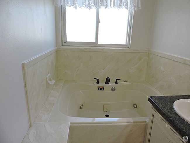 Full bathroom with plenty of natural light, a tub with jets, and vanity | Image 29