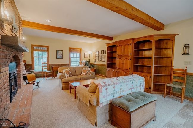 Family room featuring a brick fireplace, beamed ceiling, and recessed lighting | Image 11