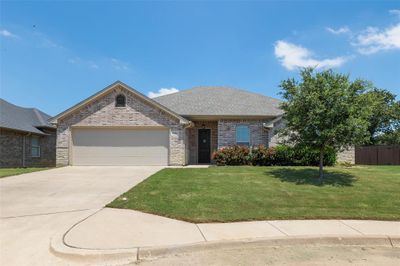 Ranch-style home with a garage and a front yard | Image 1