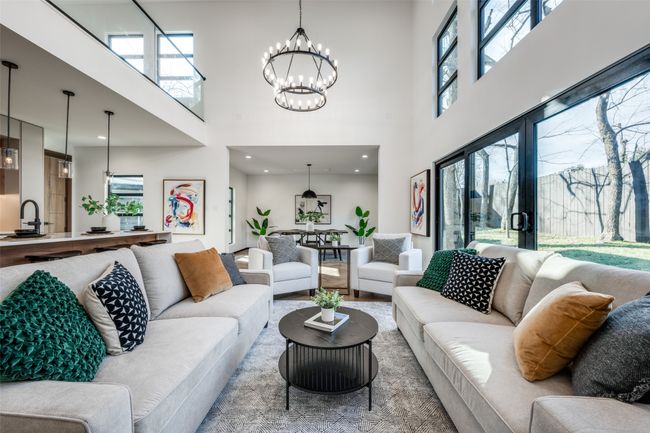 Living area with a high ceiling, a chandelier, and plenty of natural light | Image 4
