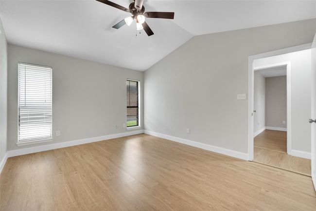 Unfurnished room with lofted ceiling, a ceiling fan, plenty of natural light, and light wood-style flooring | Image 15