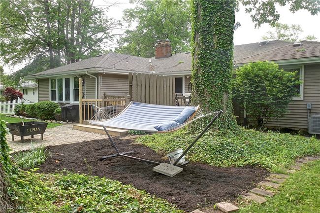Back of house with a chimney, a deck, and roof with shingles | Image 42
