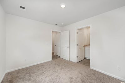 Unfurnished bedroom with light carpet and ensuite bathroom | Image 3