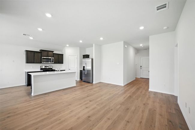 Kitchen featuring appliances with stainless steel finishes, open floor plan, light wood finished floors, recessed lighting, and light countertops | Image 4