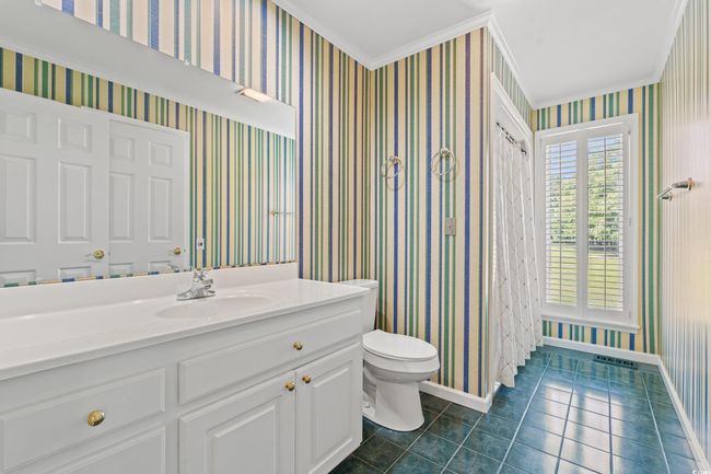Full bath with tile patterned floors, crown molding, vanity, and wallpapered walls | Image 17