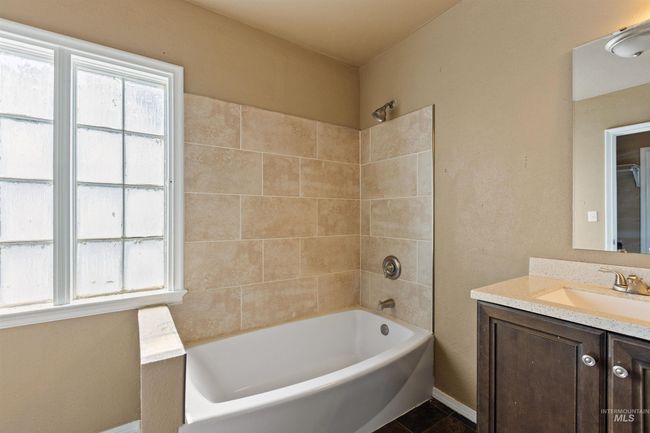 Bathroom with shower / bathtub combination, vanity, and a textured wall | Image 27