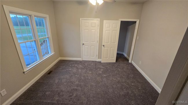 Unfurnished room featuring ceiling fan, baseboards, and dark carpet | Image 48
