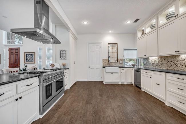 The generous kitchen has been completely remodeled with tumbled leather granite countertops and a river stone backsplash. Notice the top of the line Thor gas range and ovens. A chef's dream! | Image 5