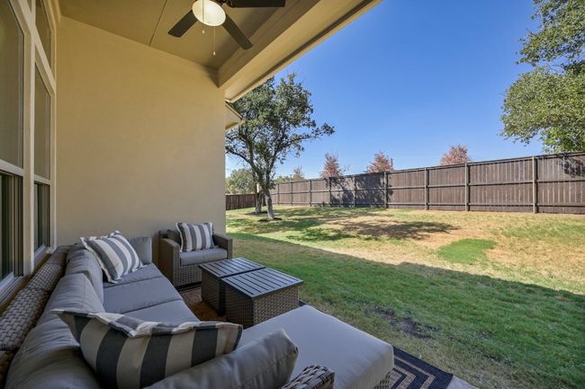 This covered space is ideal for all-weather use, featuring ample room for comfortable seating and a dining set. Enjoy your morning coffee while taking in the peaceful surroundings or host evening gatherings with friends and family. | Image 27
