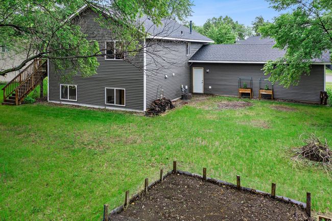 The backyard is spacious and features a garden bed that the current owners grow sunflowers and vegetables in. | Image 22