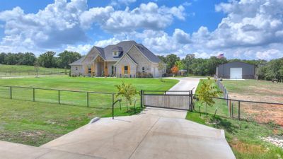 View of front facade with an outdoor structure, a rural view, a garage, and a front lawn | Image 3