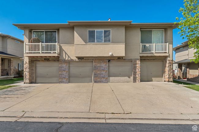 View of front facade featuring an attached garage, driveway, stone siding, and stucco siding | Image 18