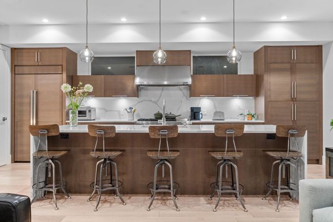 Kitchen featuring range hood, modern cabinets, light countertops, backsplash, and recessed lighting | Image 4
