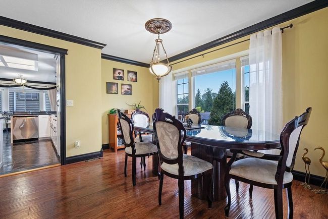Dining room featuring crown molding, baseboards, and dark wood-style flooring | Image 7